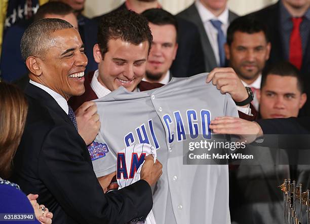 President Barack Obama shows a jersey given to him by the 2016 World Series Champion Chicago Cubs in The East Room at the White House, on January 16,...