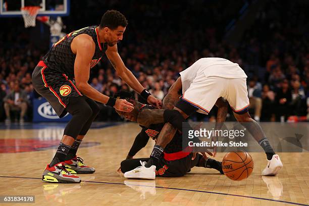 Justin Holiday of the New York Knicks scrambles for the ball against Mo Williams and Dennis Schroder of the Atlanta Hawks at Madison Square Garden on...