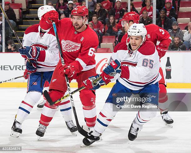 Xavier Ouellet of the Detroit Red Wings battles for position with Andrew Shaw of the Montreal Canadiens during an NHL game at Joe Louis Arena on...
