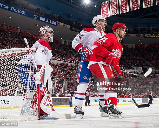 Tomas Tatar of the Detroit Red Wings battles for position with Alexei Emelin of the Montreal Canadiens in front of teammate Carey Price of the...