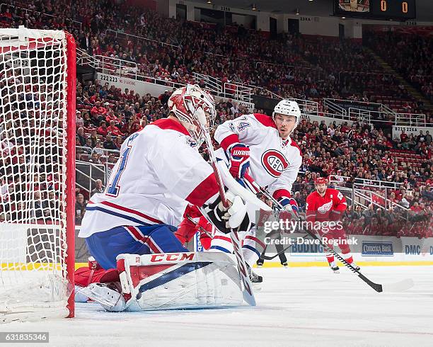 Carey Price of the Montreal Canadiens makes a save as teammate Alexei Emelin skates in for the rebound during an NHL game against the Detroit Red...