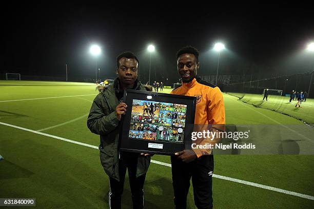 Premier League Kicks Hero Tresor Kalilwa recieves framed comic strip award from Hull City's Moses Odubajo at the KCOM astro pitches on January 16,...