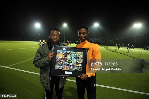 Premier League Kicks Hero Tresor Kalilwa recieves framed comic strip award from Hull City's Moses Odubajo at the KCOM astro pitches on January 16,...