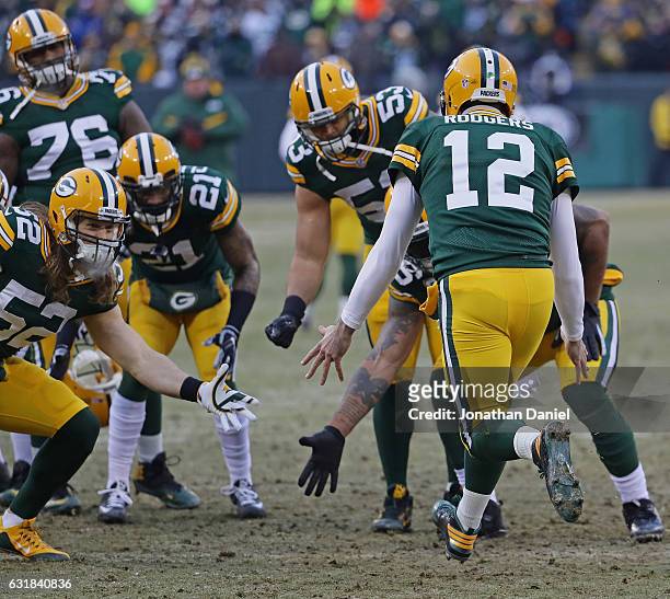Aaron Rodgers of the Green Bay Packers is greeted by teammates during player introductions before a game against the New York Giants at Lambeau Field...