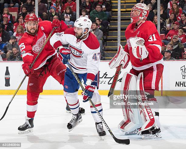 Alexander Radulov of the Montreal Canadiens battles for position with Mike Green of the Detroit Red Wings in front of Jared Coreau of the Wings...