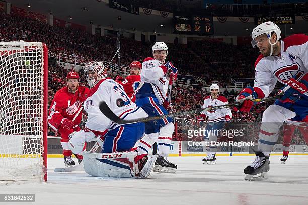 Shea Weber of the Montreal Canadiens reaches for the puck in front of teammate goaltender Carey Price as Alexei Emelin of the Canadiens and Justin...