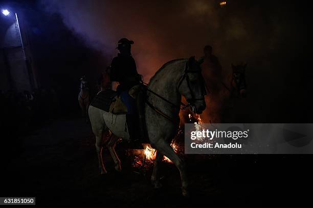 Man rides his horse through fire to purify and protect his horse during the Las Luminarias festival at the San Bartolome de Pinares village of the...