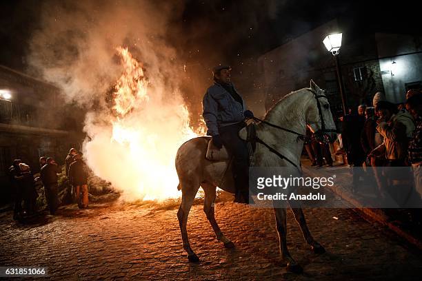 Man rides his horse through fire to purify and protect his horse during the Las Luminarias festival at the San Bartolome de Pinares village of the...