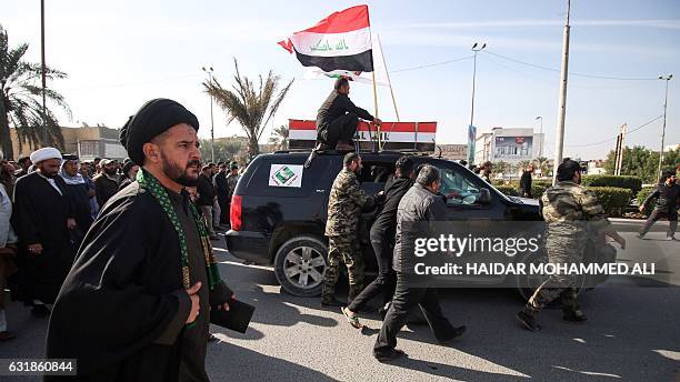 An Iraqi Shiite cleric walks in a funeral procession for a member of the Saraya al-Salam , a group formed by Iraqi Shiite Muslim cleric Moqtada...