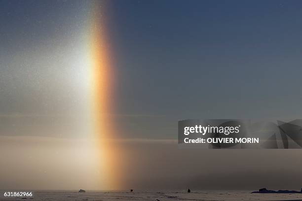 Man is ice-fishing near a solar halo on the frozen sea in Vaasa by -15°C, on January 15, 2017. The Halo is an optical phenomena produced by light...