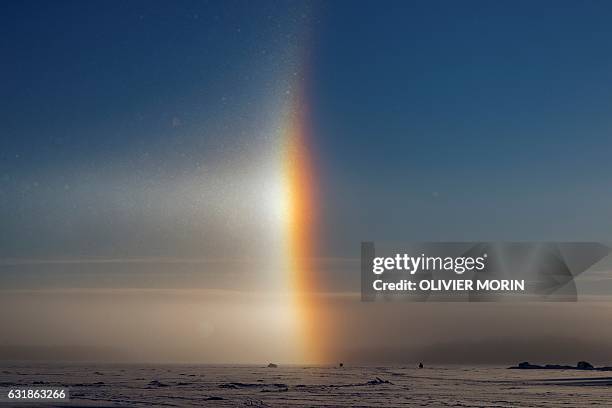 Man is ice-fishing near a solar halo on the frozen sea in Vaasa by -15°C, on January 15, 2017. The Halo is an optical phenomena produced by light...