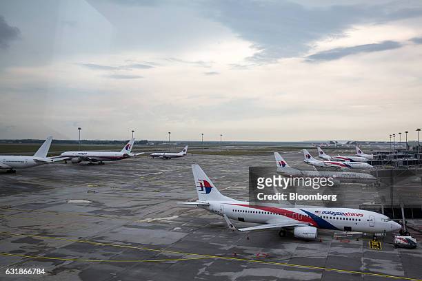 Malaysian Airlines Bhd. Aircraft are seen through a window as they stand on the tarmac at Kuala Lumpur International Airport in Sepang, Selangor,...