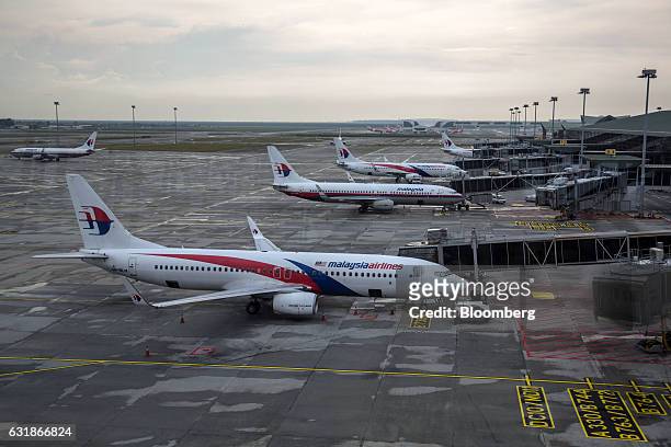 Malaysian Airlines Bhd. Aircraft are seen through a window as they stand on the tarmac at Kuala Lumpur International Airport in Sepang, Selangor,...