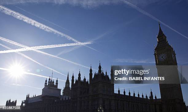 Contrails or vapour trails made by passing aircraft, are pictured in the sky above The Elizabeth Tower, better known as "Big Ben", and the Houses of...