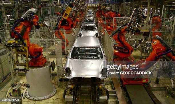 Robotic arms work on the bodyshells of Mini cars as they pass along a section of automated production line at the BMW Mini car production plant in...