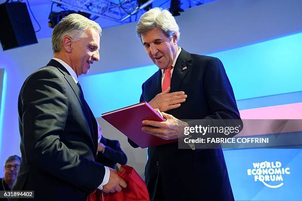 Outgoing US Secretary of State John Kerry receives a gift from Swiss Foreign Minister Didier Burkhalter after delivering remarks on the opening day...