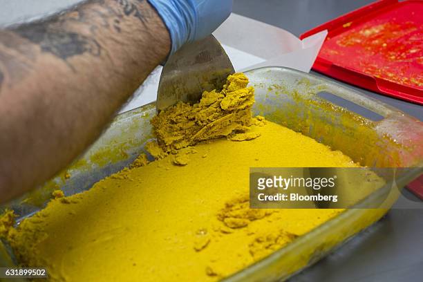 Worker scrapes marijuana wax at the Smokey Point Productions facility in Arlington, Washington, U.S., on Thursday, Jan. 12, 2017. The increasing...