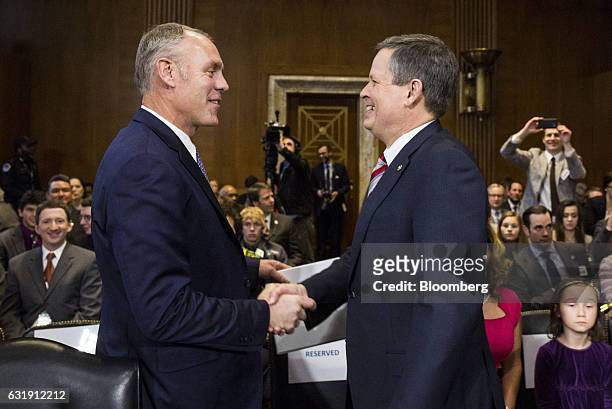Representative Ryan Zinke, U.S. Secretary of interior nominee for president-elect Donald Trump, left, shakes hands with Senator Steve Daines, a...