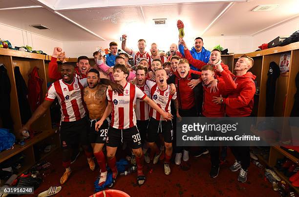 The Lincoln team and staff celebrate their victoary in the changing room after the Emirates FA Cup third round replay between Lincoln City and...
