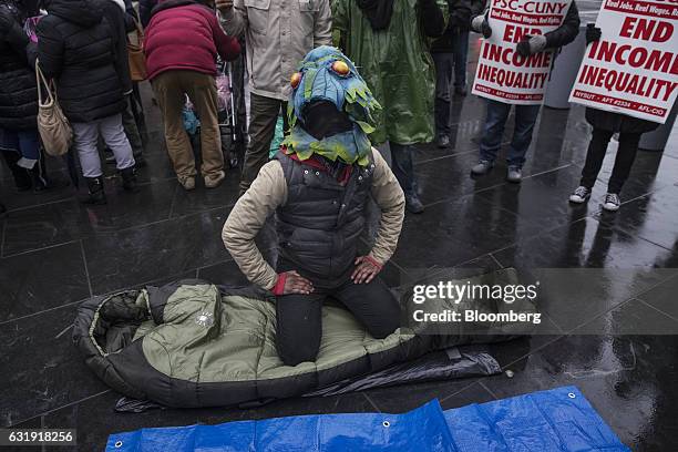 Demonstrator dressed as a swamp creature sits on a sleeping bag during a protest outside Goldman Sachs Group Inc. Headquarters in New York, U.S., on...