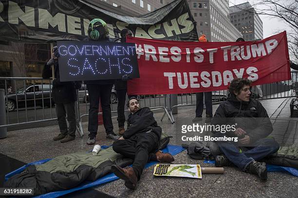 Demonstrators hold up signs and set up sleeping bags during a protest outside Goldman Sachs Group Inc. Headquarters in New York, U.S., on Tuesday,...
