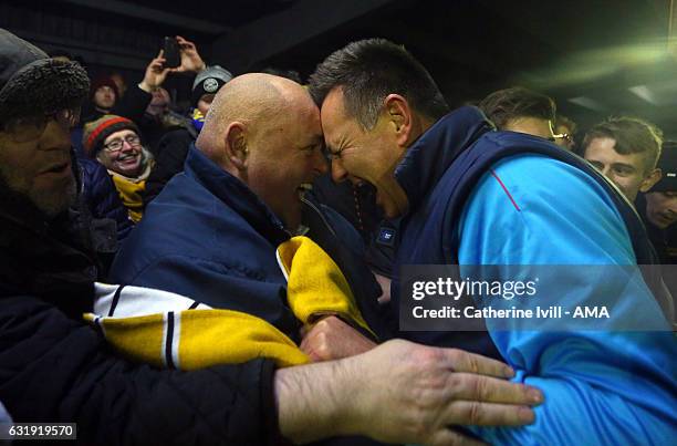 Paul Doswell manager of Sutton United celebrates with the fans after they win The Emirates FA Cup Third Round Replay match between AFC Wimbledon and...