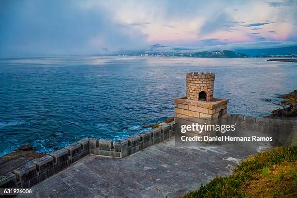 seascape at dusk with a small fortress and the town of bayona in background in galicia - vigo fotografías e imágenes de stock