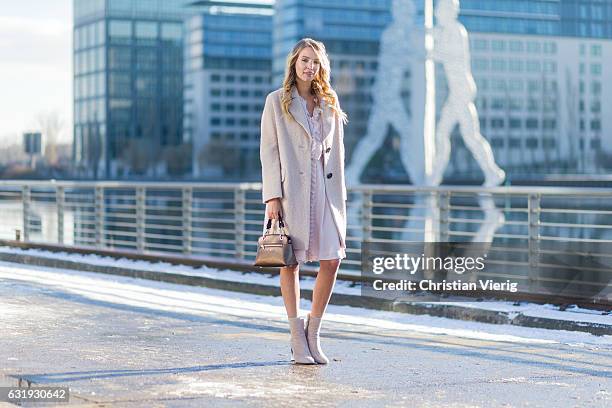 Leonie Sophie Hanne wearing a nude wool coat, ruffled dress, brown Marc Cain bag, nude Marc Cain ankle boots with socks during the Mercedes-Benz...