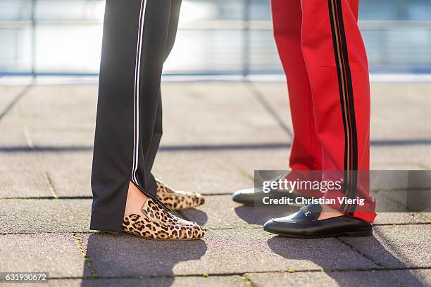 Caro Daur wearing a red track suit and Lisa Hahnbueck wearing a black track suit with leopard print and Marc Cain loafers during the Mercedes-Benz...
