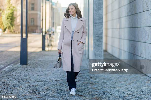 Nina Schwichtenberg wearing a nude Marc Cain wool coat, grey Marc Cain bag, navy Marc Cain jogger pants, white turtleneck, white sneaker during the...