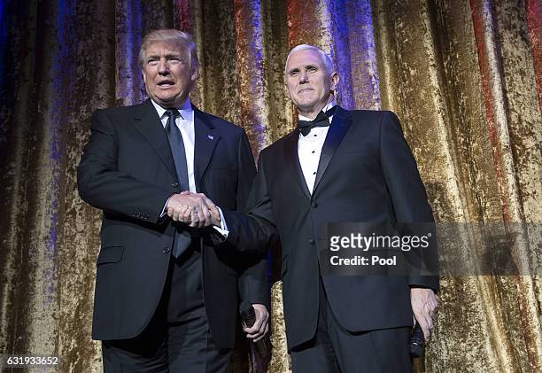 President-elect Donald Trump and Vice President-elect Mike Pence arrive on stage at the Chairman's Global Dinner, at the Andrew W. Mellon Auditorium...