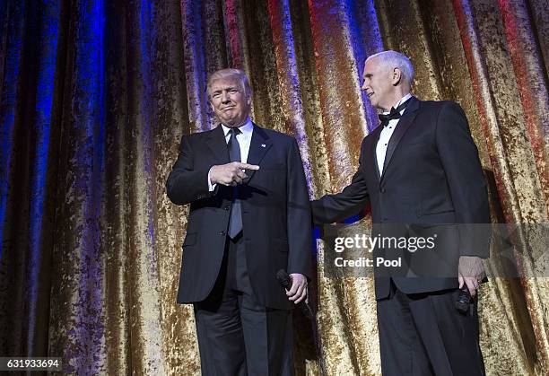 President-elect Donald Trump and Vice President-elect Mike Pence arrive on stage at the Chairman's Global Dinner, at the Andrew W. Mellon Auditorium...