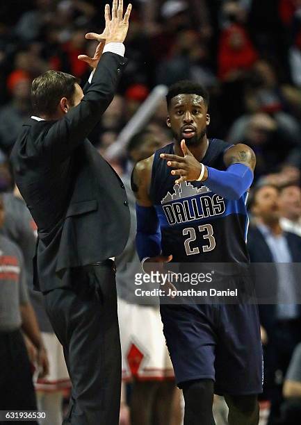 Wesley Matthews of the Dallas Mavericks reacts after hitting the game-winning shot as head coach Fred Hoiberg of the Chicago Bulls calls time out at...