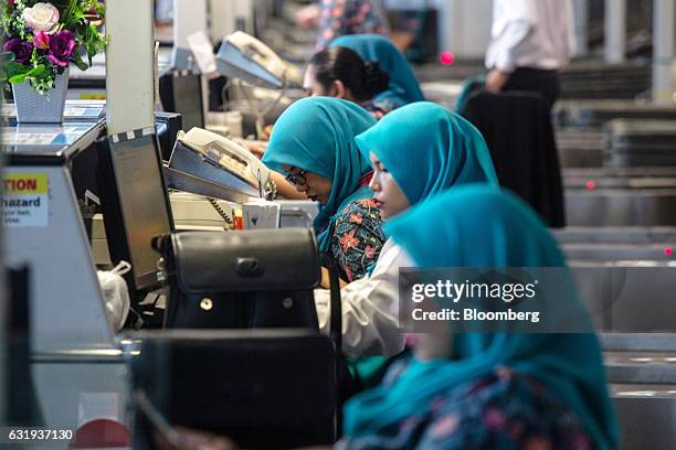 Malaysian Airlines Bhd. Ground staff work at check-in counters at Kuala Lumpur International Airport in Sepang, Selangor, Malaysia, on Tuesday, Jan....