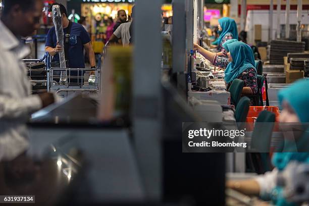 Malaysian Airlines Bhd. Ground staff work at check-in counters at Kuala Lumpur International Airport in Sepang, Selangor, Malaysia, on Tuesday, Jan....