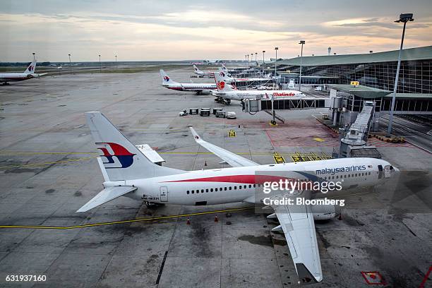 Malaysian Airlines Bhd. And Malindo Airways aircraft stand on the tarmac at Kuala Lumpur International Airport in Sepang, Selangor, Malaysia, on...