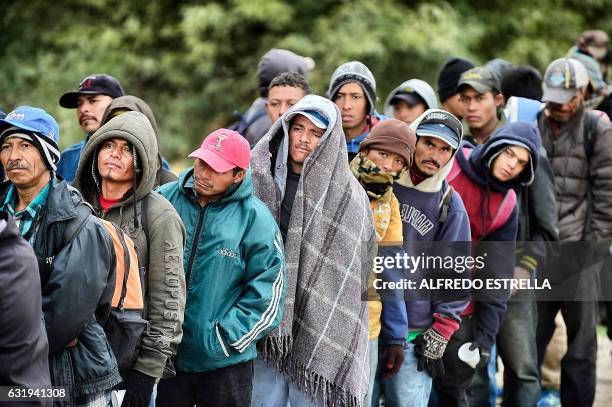 Migrants wait to receive food donated by people from the Community Center for Migrant Assistance in the community of Caborca in Sonora state, Mexico,...
