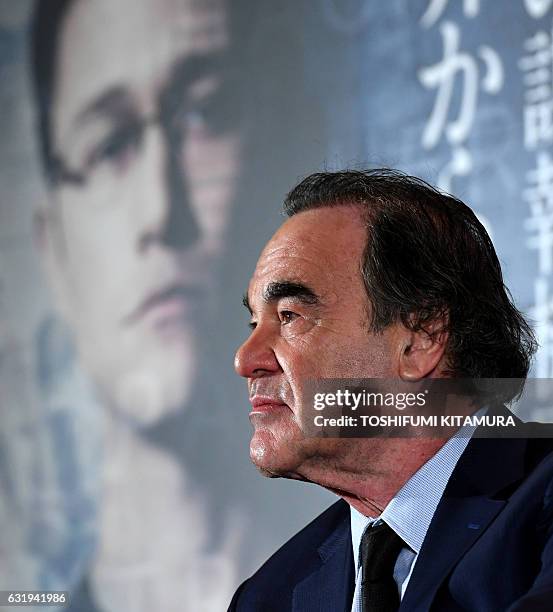 Film director Oliver Stone listens to a question during a press conference on his latest movie 'Snowden' at a hotel in Tokyo on January 18, 2017. The...