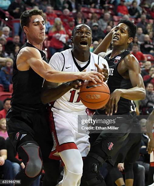 Cheickna Dembele of the UNLV Rebels is fouled by Malik Pope of the San Diego State Aztecs as Max Hoetzel of the Aztecs defends during their game at...