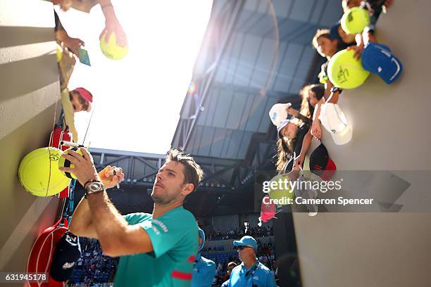 Stan Wawrinka of Switzerland signs autographs for fans after winning his second round match against Steve Johnson of the United States on day three...