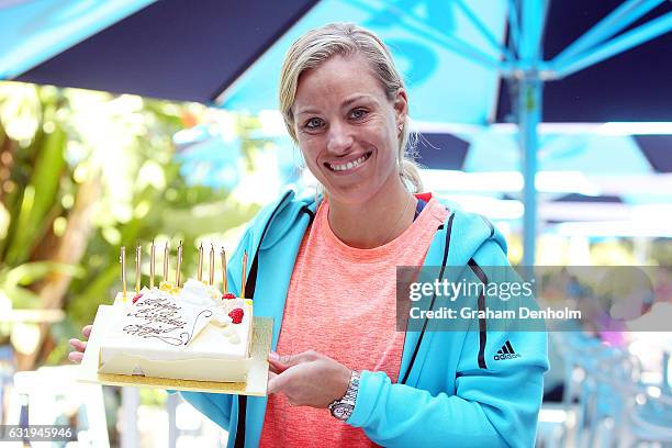 Angelique Kerber of Germany poses with a birthday cake which was presented to her by Australian Open Tournament Director Craig Tiley during day three...