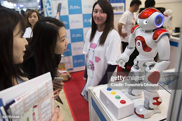 Visitors look at a NAO humanoid robot, developed by Aldebaran Robotics SA performs at the Robodex trade show on January 18, 2017 in Tokyo, Japan....