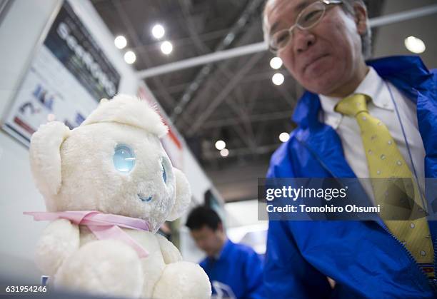 Booth attendant interacts with a RayTron Inc. Chapit communication robot at the Robodex trade show on January 18, 2017 in Tokyo, Japan. Approximately...