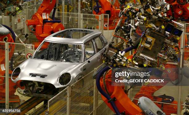 Minis in the 'Body in white' stage of manufacture pass along a robotic assembly line at the BMW Mini car production plant in Oxford, west of London,...