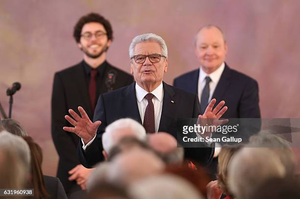 German President Joachim Gauck gestures to the audience as he stands in front of musicians after he gave a speech to mark the end of his term as...