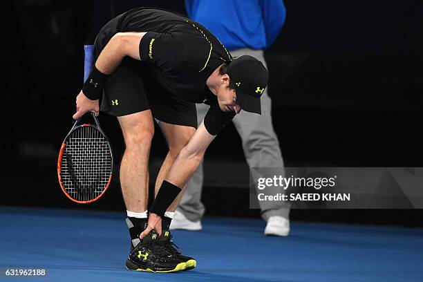 Britain's Andy Murray checks his ankle after falling during a point against Russia's Andrey Rublev in their men's singles match on day three of the...