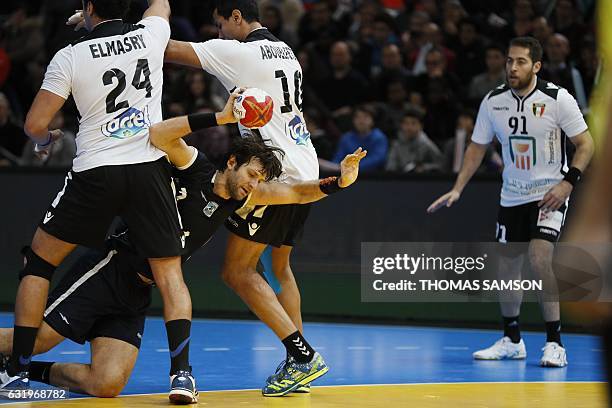 Argentina's right back Federico Vieyra falls with the ball between Egypt's pivot Ibrahim Elmasry and Egypt's right back Abouelfetoh Abdelrazek during...