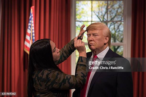 Hair stylist Gemma Sim puts finishing touches in place as Madame Tussauds unveils a wax figure of President-Elect Donald J. Trump ahead of the...