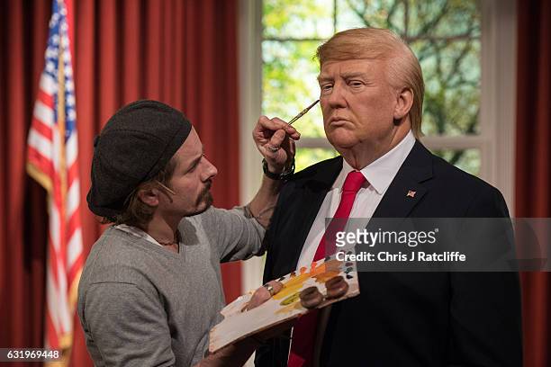Make up artist Chris Gargiulo puts finishing touches in place as Madame Tussauds unveils a wax figure of President-Elect Donald J. Trump ahead of the...