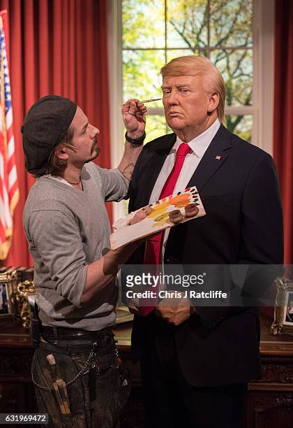 Make up artist Chris Gargiulo puts finishing touches in place as Madame Tussauds unveils a wax figure of President-Elect Donald J. Trump ahead of the...